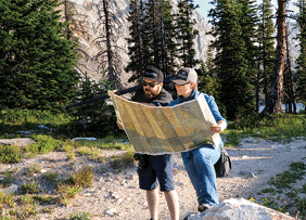 Two people are standing in a forest, looking at a map. AI generated content