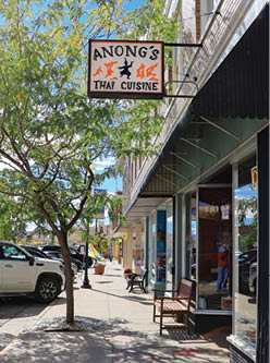 A sign for a Thai cuisine restaurant is on the side of a building. AI generated content